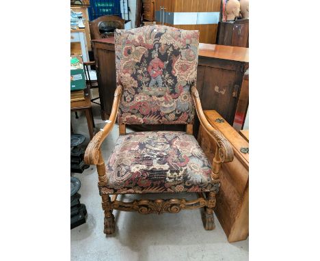 An oak framed high back tapestry chair with carved arms and heavy paw feet; an alabaster lamp.
