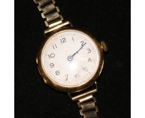 A lady's 18ct gold manual wind wrist watch on a gilt metal bracelet.