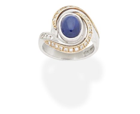 SAPPHIRE AND DIAMOND RINGThe oval sapphire cabochon between two obliquely set rows of brilliant-cut diamonds,  ring size appr