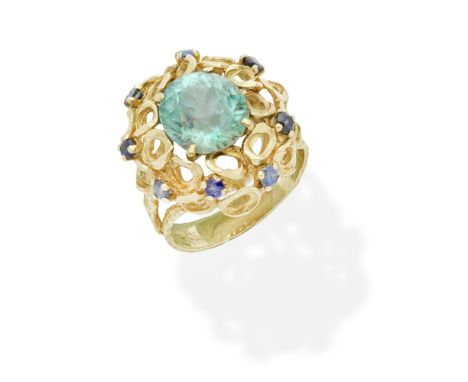 ALAN MARTIN GARD: GEM-SET RING, 1967Of 18 carat gold openwork abstract design, set with an oval-cut blue zircon and circular-