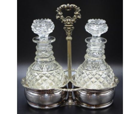 Antique twin decanter silver plate tantalus pair cut crystal decanters, (1 with stopper chipped),  in decorative silver plate