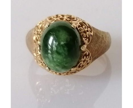 A jade oval cabochon gold ring, the jade stone approximately 10mm x 8mm, on an 18ct gold carved setting, stamped, size I1/2, 