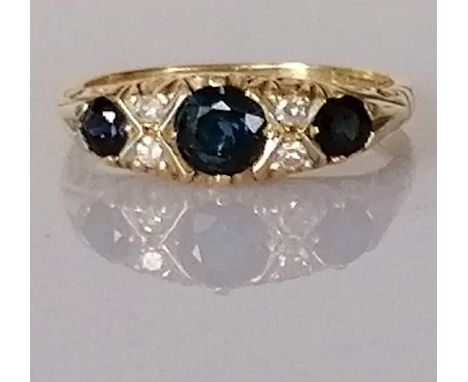 A graduated three-stone sapphire and diamond ring on a carved 18ct yellow gold setting, the largest sapphire approximately 0.