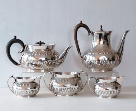 A late Victorian silver tea set comprising teapot, sugar bowl and jug of oval form with embossed decoration, initialled, by M