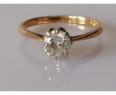 A solitaire diamond ring in a claw-set gold setting, the round-cut diamond approximately 0.75 carats, size M, stamped 18ct, 1