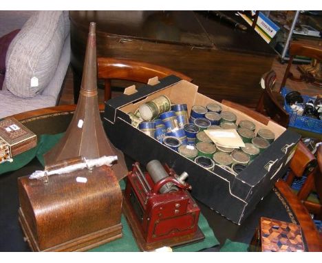 An Edison phonograph with original red paint, oak carrying case and metal horn, together with a large selection of music cyli