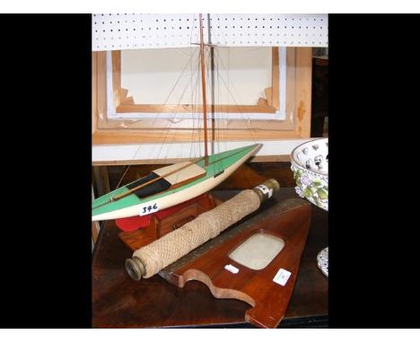 An unusual photo frame in the form of a propeller tip, model yacht and telescope 