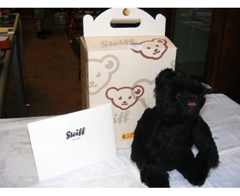 A collectable Steiff Teddy Bear 'Joshua' with squeezer - black with Certificate - 33cm long - boxed 