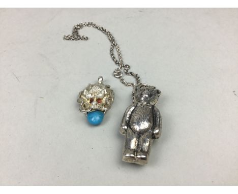 SILVER TEDDY BEAR PENDANT, on chain, along with a white metal dragon's head pendant (2)