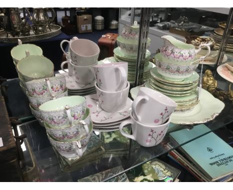 PARAGON TEA SERVICE, with floral and gilt decoration, comprising six trios, sugar, cream and serving plate, along with four '