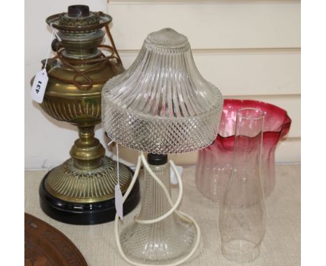 A brass oil lamp with shade and chimney, height 38cm and a glass table lamp