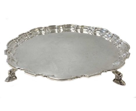 A George V silver salver, mark of Mappin &amp; Webb, Sheffield 1930, 'Chippendale' style, raised on three decorative hoof fee