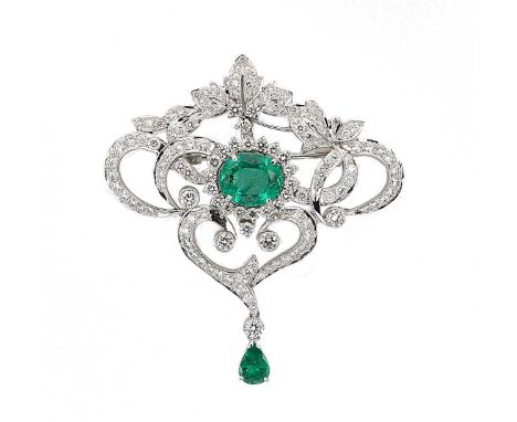 An emerald and diamond pendant/brooch, openwork scroll design with a claw set oval faceted emerald, approximately 12.75 x 10.