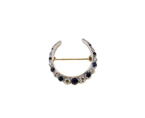 A late 20th century 9ct gold, sapphire and diamond crescent brooch, nine graduated round faceted sapphires, diameter from 1.4