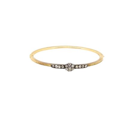A Victorian diamond set hinged bangle, central diamond set floral cluster, with a row of diamonds either side, estimated appr
