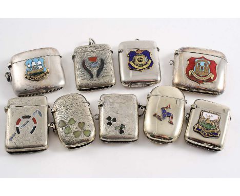 FIVE EARLY 20TH CENTURY VESTA CASES with applied enamel badges, two late Victorian plated "Scottish market" vesta cases with 