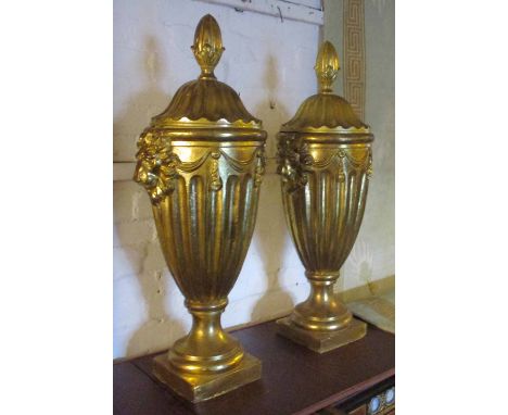 URNS WITH COVERS, a pair, gilt coloured, each with a turned finial, lion mask and swag decoration, 85cm H. (2)