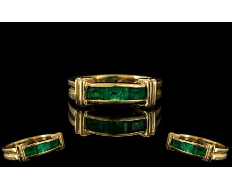 An 18ct Gold Emerald Ring Three channel set baguette emeralds stamped 18K. Ring size L/M.  