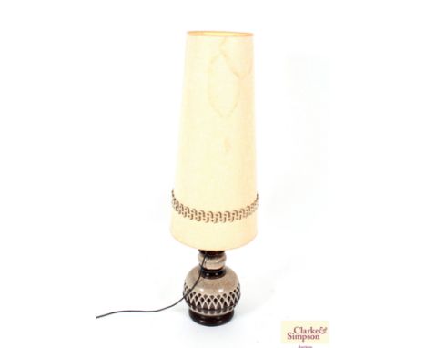 A large pottery table lamp with pierced decoration and tall shade