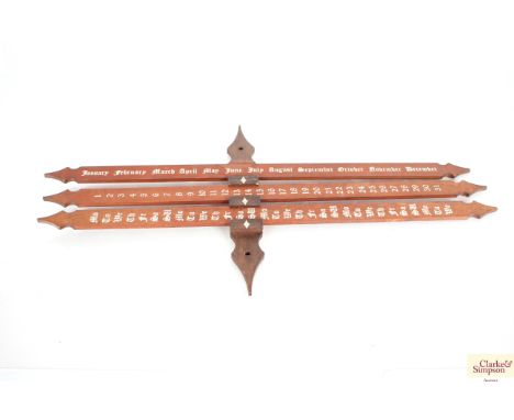 An unusual wooden calendar of arrow shape, 75cm long