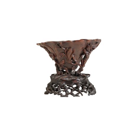 RHINOCEROS HORN 'MAGNOLIA AND PRUNUS' LIBATION CUP, KANGXI PERIOD of naturalistic form, the side carved with a chilong clambe