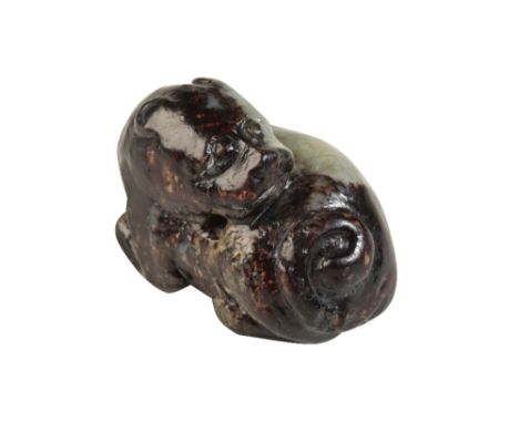 SMALL RUSSET JADE CARVING OF A LION, MING DYNASTY shown with its head turned backwards over its body, Width: 4cm  