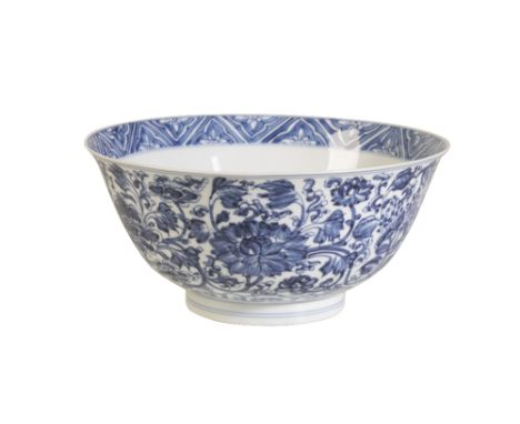 BLUE AND WHITE BOWL, KANGXI SIX CHARACTER MARK AND OF THE PERIOD the sides painted in tones of underglaze blue with scrolling