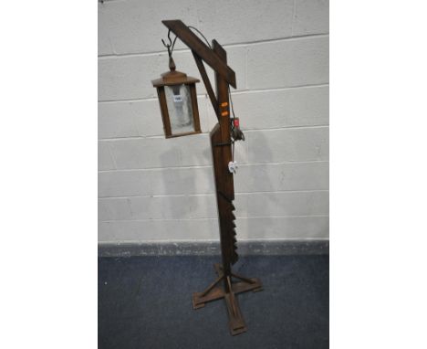 AN ARTS AND CRAFTS STYLE OAK STANDARD LAMP, with adjustable height clasp and a four sided glass lantern
