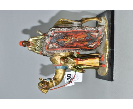 A COLD PAINTED SPELTER TABLE LIGHTER IN THE FORM OF TWO FIGURES WITH A CAMEL, in the style of Bergman, mounted on a rectangul