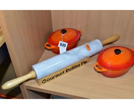 A PAIR OF LE CREUSET ORANGE GLAZED OVAL CERAMIC  INDIVIDUAL CASSEROLE DISHES AND COVERS, impressed marks to the bases, length