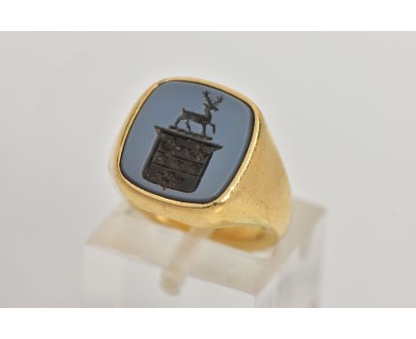 A MODERN 18CT GOLD HARD STONE SIGNET RING, the hardstone carved to depict a coat of arms with stag, to the plain polished tap