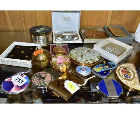 SIXTEEN POWDER COMPACTS TOGETHER WITH A MUSICAL DRESSING EXAMPLE, to include a silver compact with a glamourous female figure