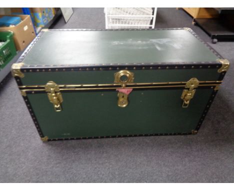 A metal bound shipping trunk containing curtains, bedding, etc (green). 