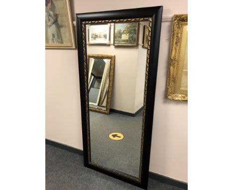 A 5' by 2' mirror in a black and gilt frame 