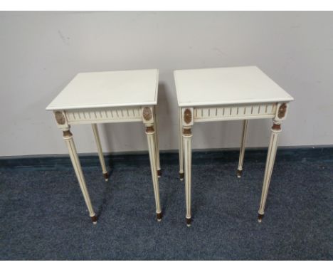 A pair of white and gilt lamp tables on reeded legs.   