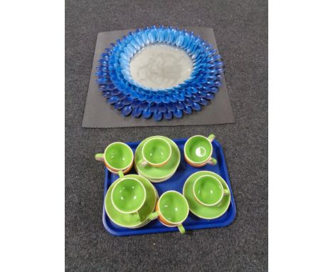 A circular contemporary mirror together with a tray containing Jones teacups and saucers 