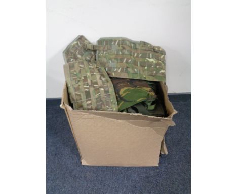 A box containing a quantity of army surplus items. 