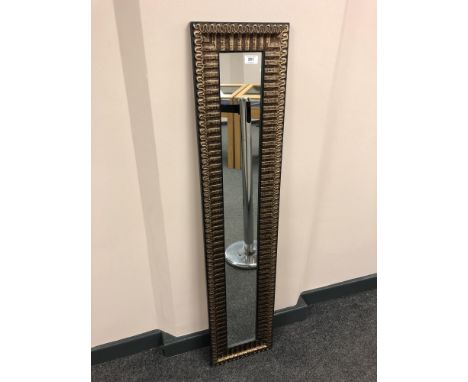 A slim, silvered hall mirror 