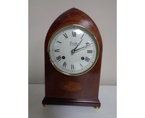 An inlaid mahogany mantel clock by Comitti of London on raised brass feet 