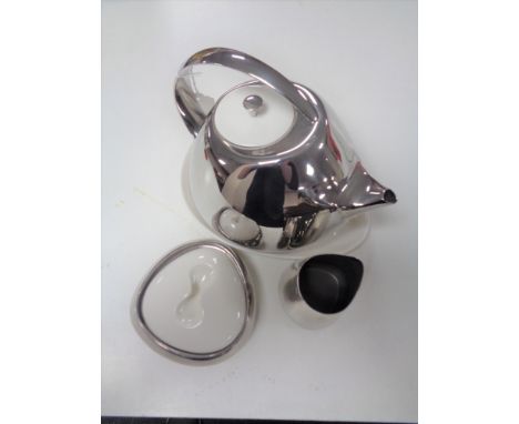 A Georg Jensen three piece tea service comprising teapot with ceramic lid on ceramic stand, a sugar bowl with ceramic lid and