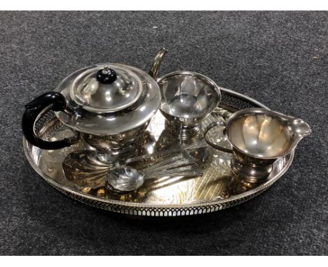 A silver plated gallery tray on raised feet together with a three piece Sheffield Plate tea service and a set of dessert spoo