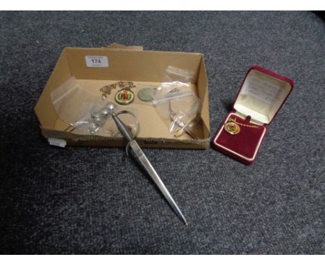 A box containing a Dutch coin bracelet, King George V medal, two enamel coins in silver mounts, a tie pin letter opener etc. 