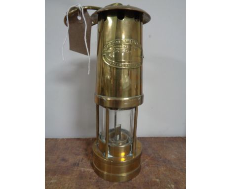 A brass miner's lamp by E. Thomas and Williams. 