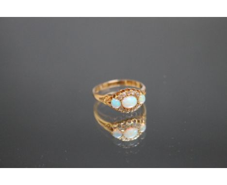 A HALLMARKED 18 CARAT GOLD THREE STONE OPAL AND DIAMOND RING, ring size S