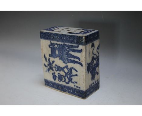 AN ORIENTAL CERAMIC PILLOW DECORATED WITH A SCHOLARS' DESK AND DOGS OF FO, of typical form in mainly blue and white, H 14.25 