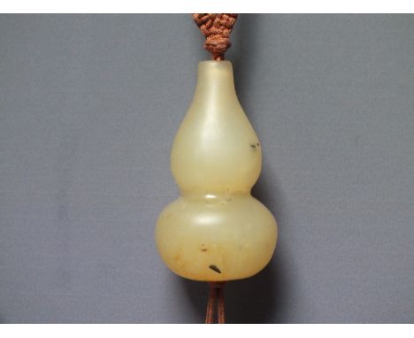 A CHINESE YELLOW JADE  GOURD PENDANT, finely carved in simple form,  H 5 cm, suspended form a silk tasselled cord having four