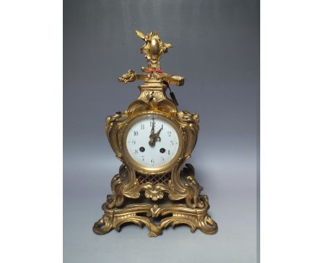AN ORNATE FRENCH STYLE GILT MANTLE CLOCK, circular enamel face with Arabic numerals, 8 day movement striking on a single bell