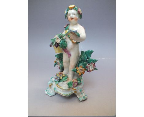 AN 18TH CENTURY DERBY PORCELAIN FIGURE, the cherubic figure amongst flowers with a floral sash, standing on a raised base wit