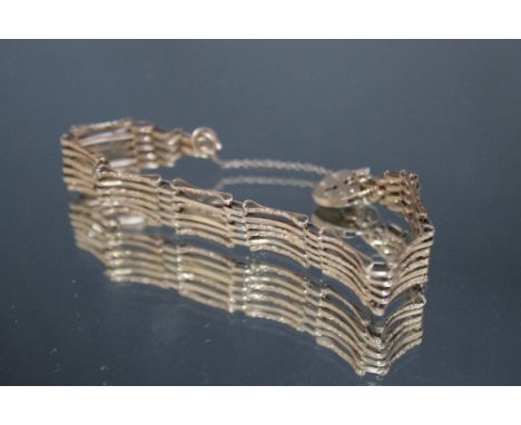A 9CT GOLD SIX BAR GATE BRACELET, with attached safety chain and hallmarked heart shaped clasp, approx. 9 g