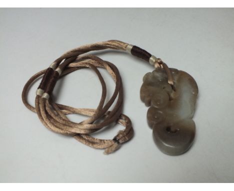 A CARVED BROWN JADE FIGURAL PENDANTS IN THE FORM OF MYTHICAL DRAGON, finely carved in shallow relief, H 6.7 cm